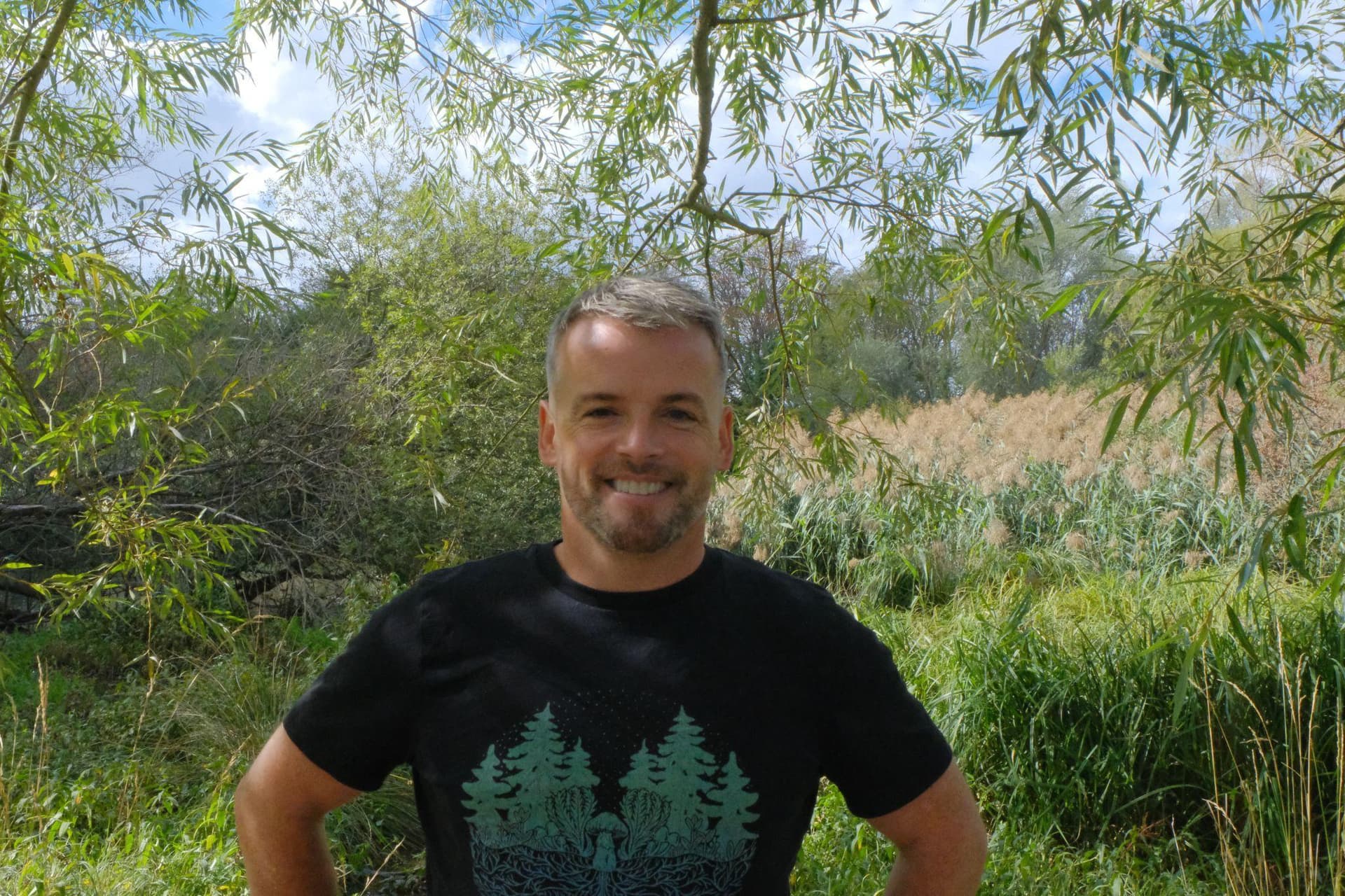 Sean McCormack standing among trees and wetland vegetation at the Ealing Beaver Project
