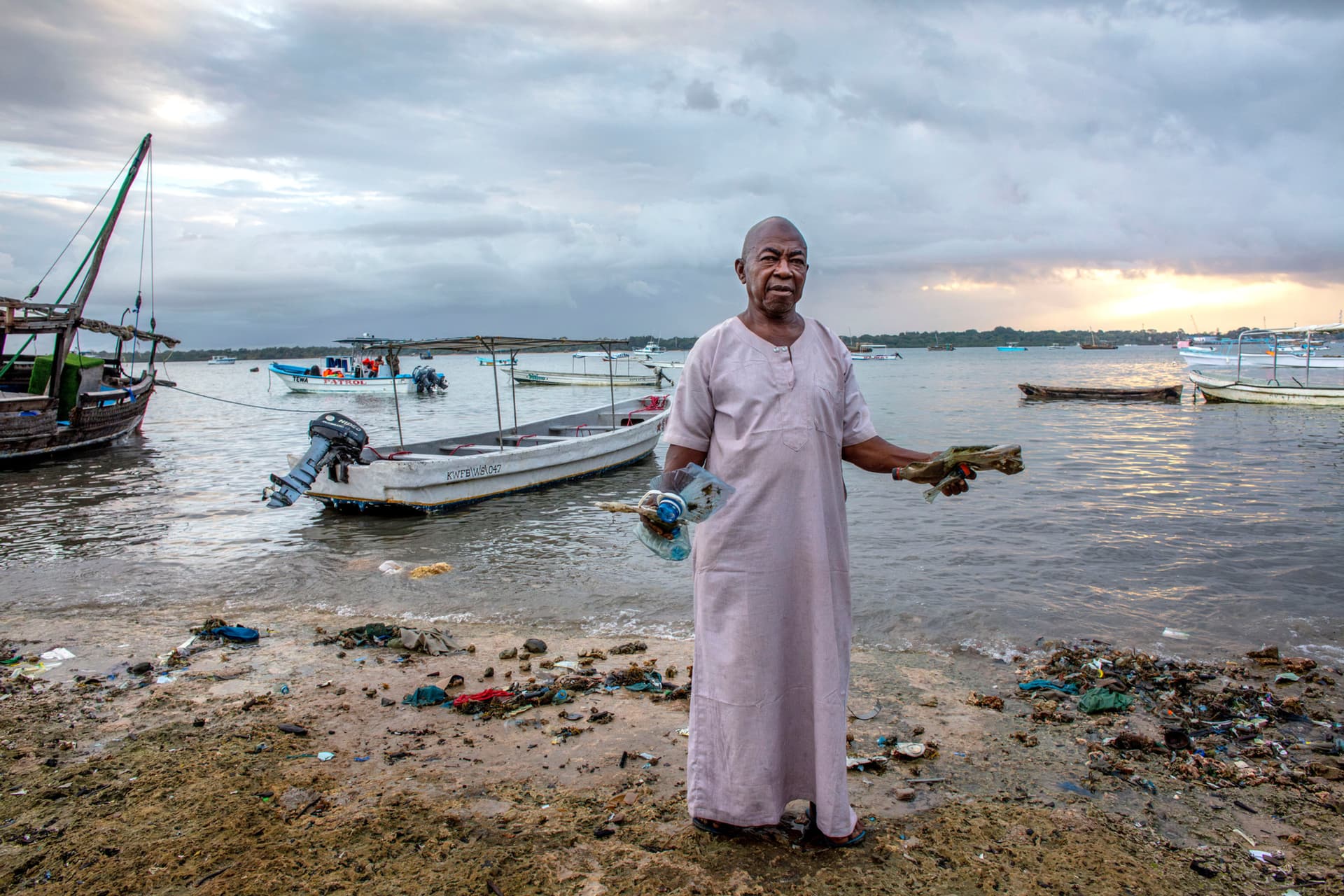 A community elder holds plastic collected during a weekly beach clean-up. Changing ocean conditions are bringing increasing amounts of waste onto these shores, turning clean-up efforts into a regular part of daily life. For coastal communities, protecting the shoreline is closely tied to protecting their own future. Photo © Georgina Goodwin