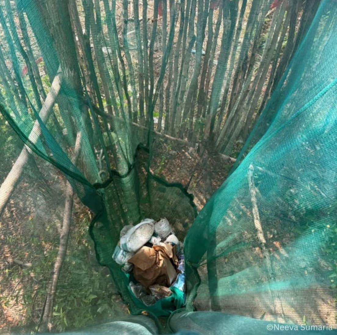 A net bag actively in use to collect waste from the village area